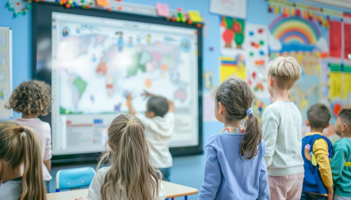 Elementary students gathered around an interactive classroom display