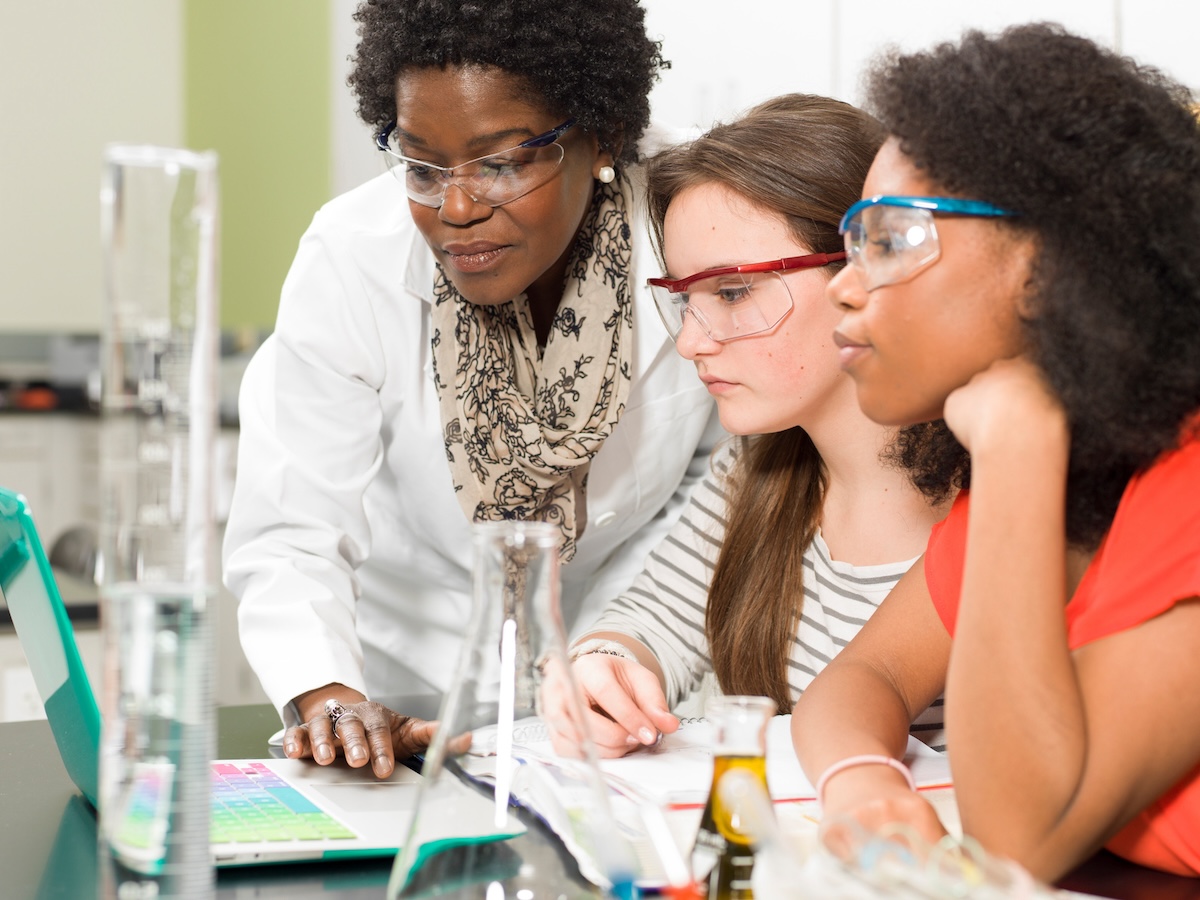 Teacher and students working together in a chemistry lab