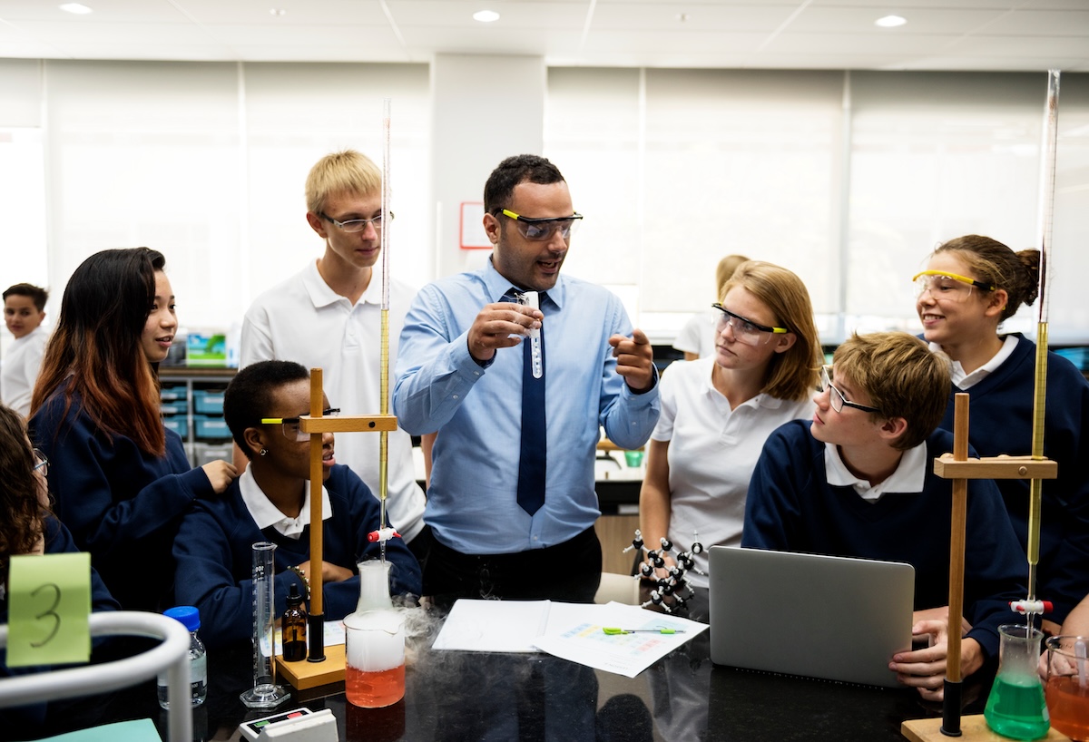Teacher and students wearing safety goggles during a science lab